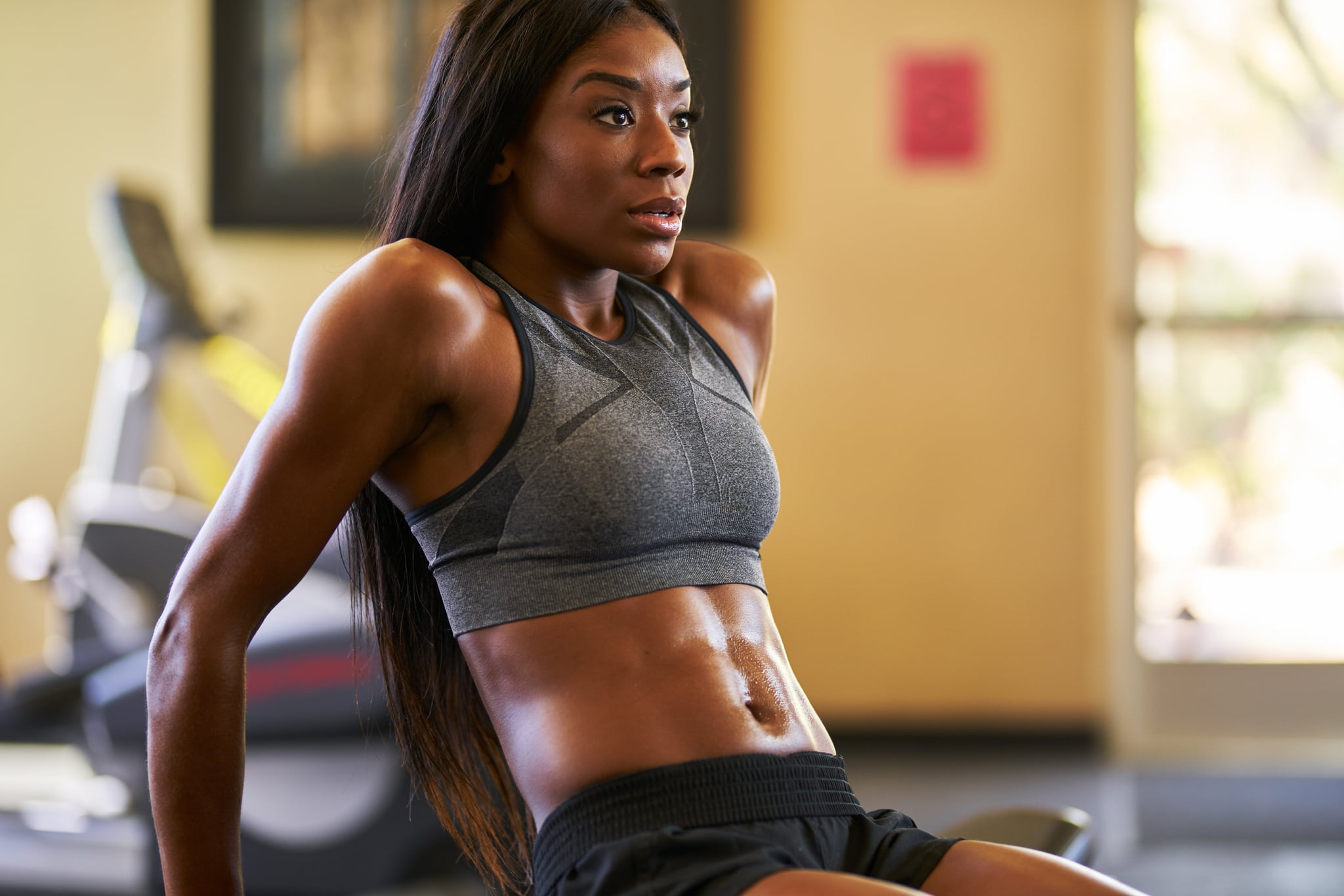 подтянутая африканская американка тренируется и растягивается в спортзале крупным планом