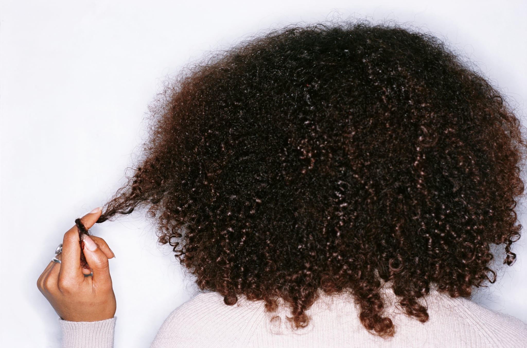 Женщина закручивает локоны после того, как научилась укладывать кудрявые волосы